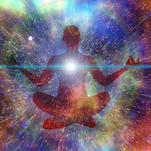 Image of a person seated in a meditation pose whilst being completely absorbed in the magical, colourful realms of deep space, being at one of the universe